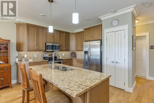 Kitchen island with granite countertop, stainless steel appliances, and wood cabinets. - 20 Mackinnnon Court, Kentville
