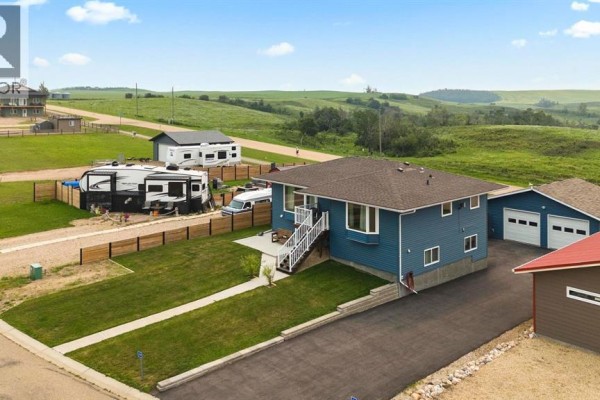 Exterior view of the blue house with a driveway, garage, and RV parking. - 20 Marina View, Rural Stettler No  6, County Of