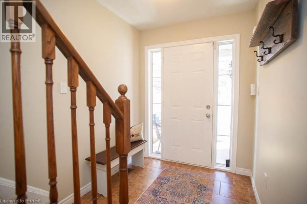 Living area with hardwood floors, TV, dining table, and kitchen island. - 20 Mcconkey Crescent Unit# 67, Brantford