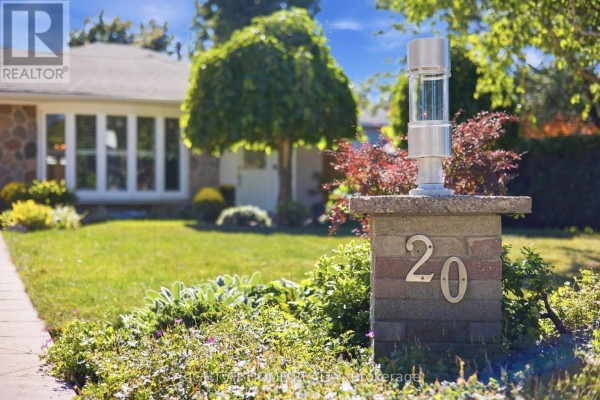 Close-up of a brick pillar with a modern light fixture and house number 20. - 20 Mono Court, Brampton