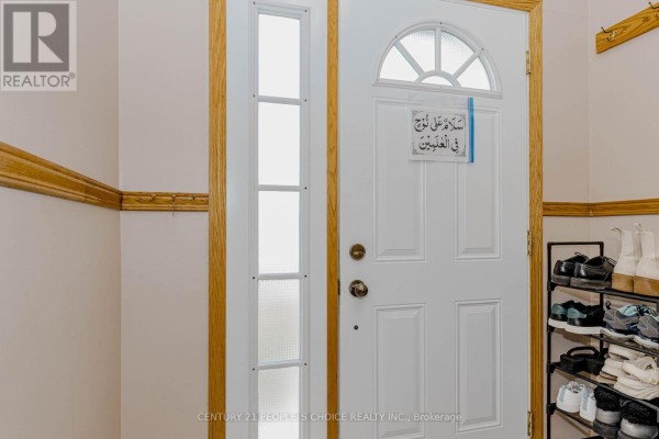 Interior view of the entryway showing a white door with a glass transom and shoe rack. - 20 Normajean Avenue, Hamilton