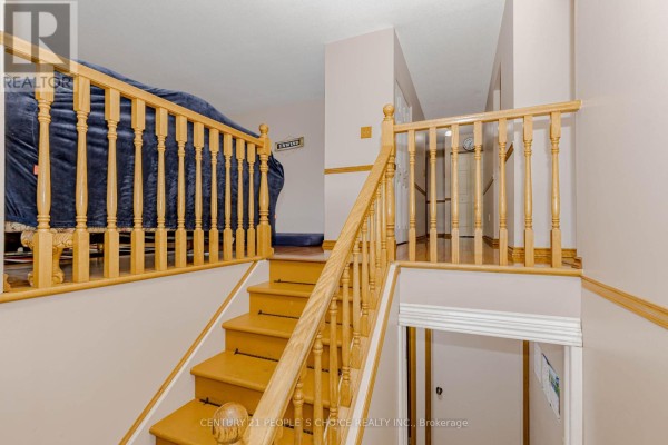 View of a staircase with light wood banisters and yellow treads leading to a hallway. - 20 Normajean Avenue, Hamilton