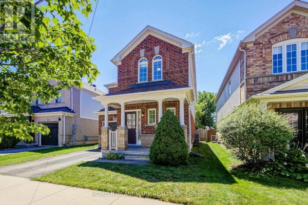 Side view of the front exterior of a two-story brick house with a covered porch. - 20 Richard Coulson Crescent, Whitchurch Stouffville