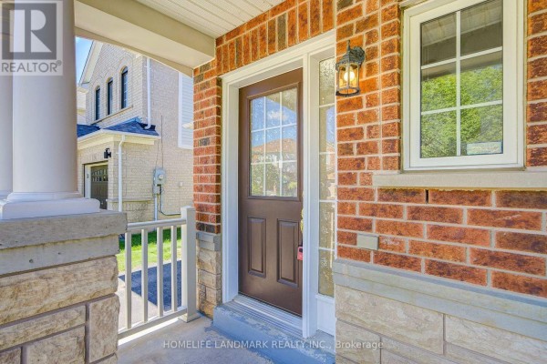 Close-up view of the front door with glass panels and sidelights, set in a brick facade. - 20 Richard Coulson Crescent, Whitchurch Stouffville
