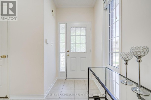 Interior entryway with a glass-paned door, tiled floor, and a console table with decorative items. - 20 Richard Coulson Crescent, Whitchurch Stouffville
