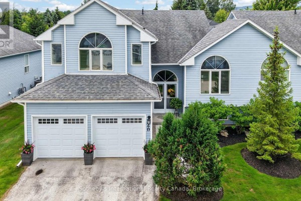 Front exterior of a blue townhouse with a gray roof, double garage, and manicured landscaping. - 20 Sundial Court, Collingwood