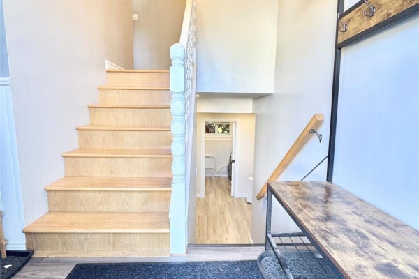 View down stairs from entryway showing shoe rack, coat rack, and doorway. - 20 Tizzard Street, Lewisporte