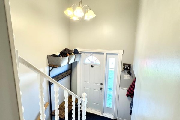 View of front door from above, showing coat rack and entryway stairs. - 20 Tizzard Street, Lewisporte