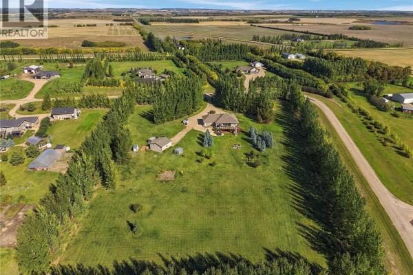 Aerial view of a large property with a house, outbuildings, and surrounding trees. - 20 Werschner Drive, Dundurn Rm No  314