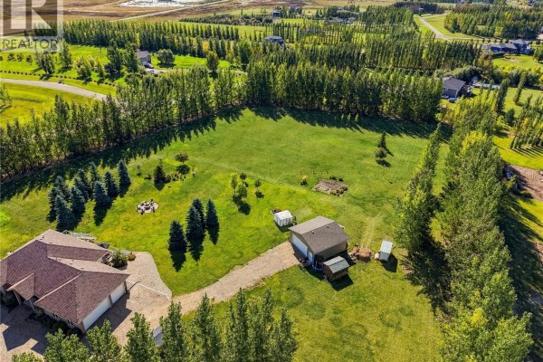 Aerial view of the rear of the house with a detached garage and open green space. - 20 Werschner Drive, Dundurn Rm No  314
