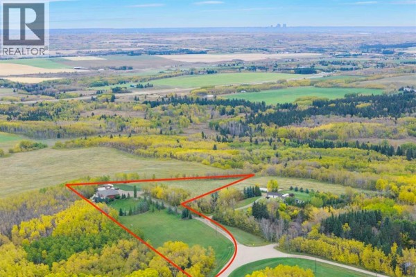 Aerial view of a property showing a house surrounded by trees and fields. - 200, 200042 198 Avenue W, Rural Foothills County