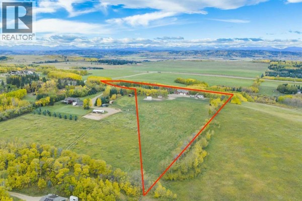 Aerial view of the property highlighting the house, land, and surrounding green space. - 200, 200042 198 Avenue W, Rural Foothills County