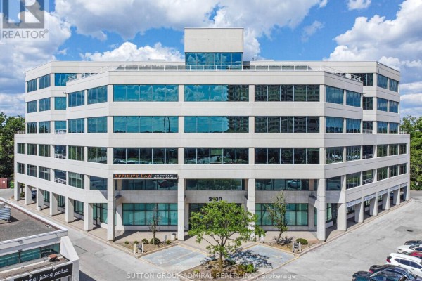 Close-up aerial view of the commercial building showcasing its glass facade and surrounding greenery. - 200 - 3100 Steeles Avenue W, Vaughan