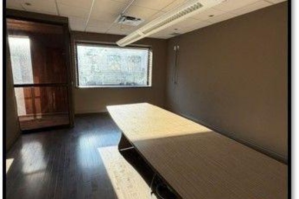 Conference room with a long wooden table, chair, and a single window. - 200 - 484 Richmond Street, London East