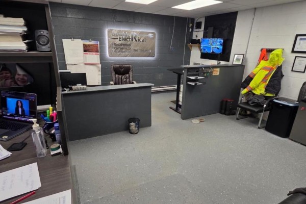 View of an office with reception desks, high-visibility jackets, and filing cabinets. - 200 - 90 Anne Street, Barrie
