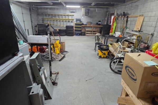 Storage and workshop area with tools, ladders, tires, and various equipment. - 200 - 90 Anne Street, Barrie