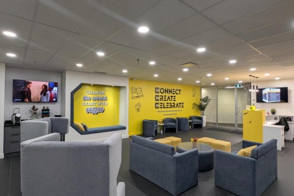 Office waiting area with yellow accent wall, comfortable seating, and television screens. - 200-17 - 350 Burnhamthorpe Road W, Mississauga