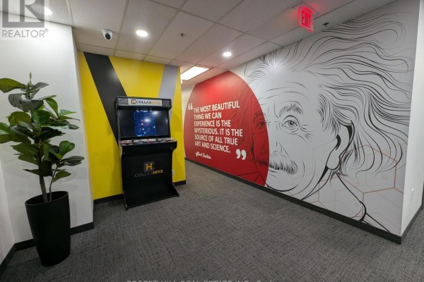 Office hallway with a large Albert Einstein mural and a vintage arcade game. - 200-17 - 350 Burnhamthorpe Road W, Mississauga