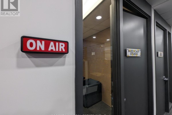 A red 'ON AIR' sign next to doors labeled 'BUZZ-CAST STUDIO' and 'EDIT BAY'. - 200-17 - 350 Burnhamthorpe Road W, Mississauga