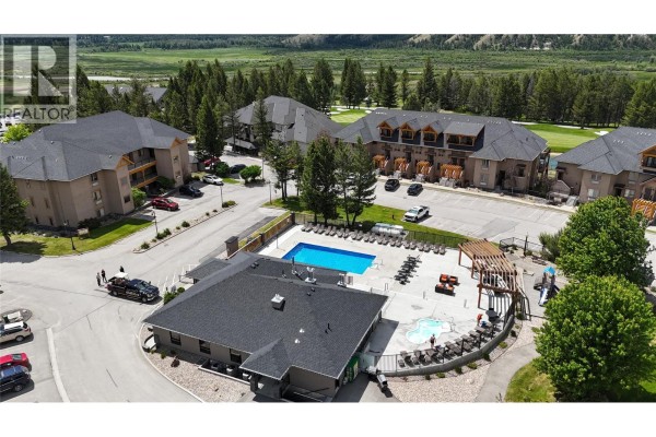 Aerial view of apartment buildings, showing a swimming pool and hot tub area. - 200 Bighorn Boulevard Unit# 233, Radium Hot Springs