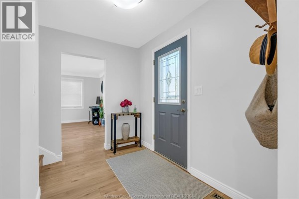 Interior entryway with gray door, light wood floors, and a console table with vase. - 200 Centre Street, Essex