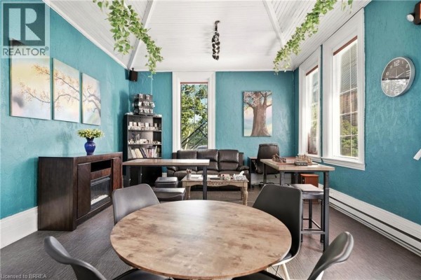 Interior room with teal textured walls, vaulted ceiling, and artwork. - 200 Grand River Avenue, Brantford