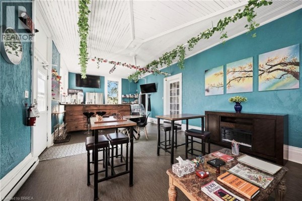 Interior view of a room with a reception counter, seating, and artwork on teal walls. - 200 Grand River Avenue, Brantford