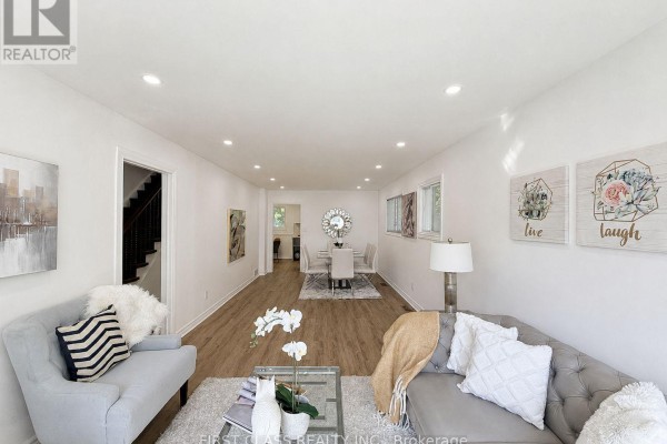 Wood-paneled room with a sofa, desk, and fireplace, decorated with abstract art. - 200 Mcnicoll Avenue, Toronto