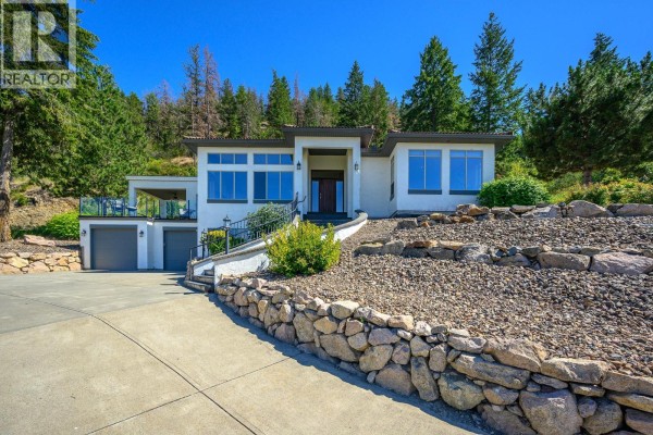 View from the entrance showcasing the lake and hills through the columns. - 200 Melrose Court, Vernon