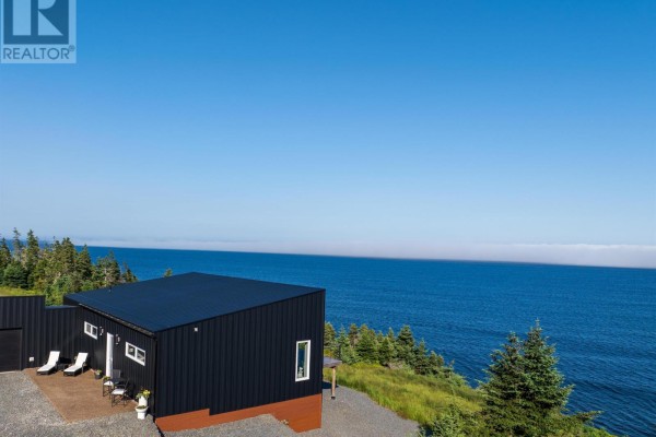 View from above of a black house with a deck and the expansive blue ocean. - 200 Middle Road, Kingsburg