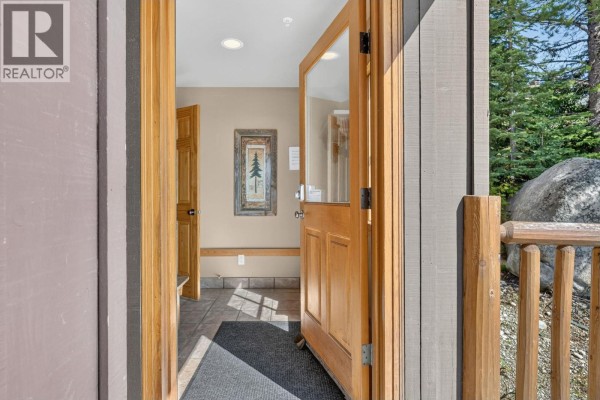 Open front door showing tile flooring, a dark mat, and a framed forest picture. - 200 Moonshine Crescent Unit# 11, Big White