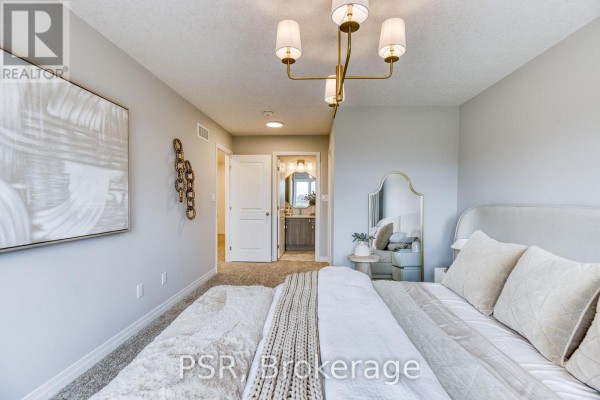 Bedroom with a large bed, neutral tones, soft textures, and an adjacent bathroom entrance. - 200 Rivergreen Crescent, Cambridge
