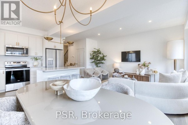 Living room and kitchen with sectional sofa, island, and stainless steel appliances - 200 Rivergreen Crescent Waterloo