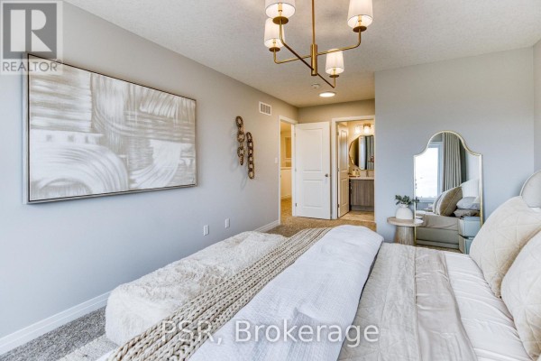 Spacious bedroom featuring a bed, ottoman, contemporary art, and access to an en-suite bathroom. - 200 Rivergreen Crescent, Cambridge