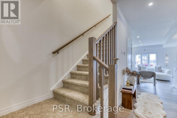 Carpeted stairs with wooden banister, open concept living area - 200 Rivergreen Crescent Waterloo