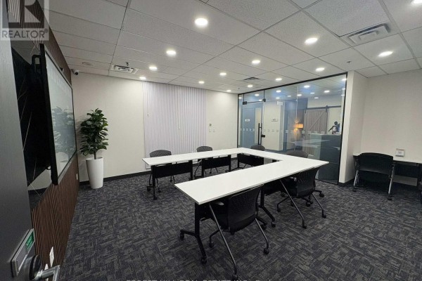 U-shaped conference table with black chairs in a room with large monitor and plant. - 200 Suite 1-4 - 350 Burnhamthorpe Road W, Mississauga