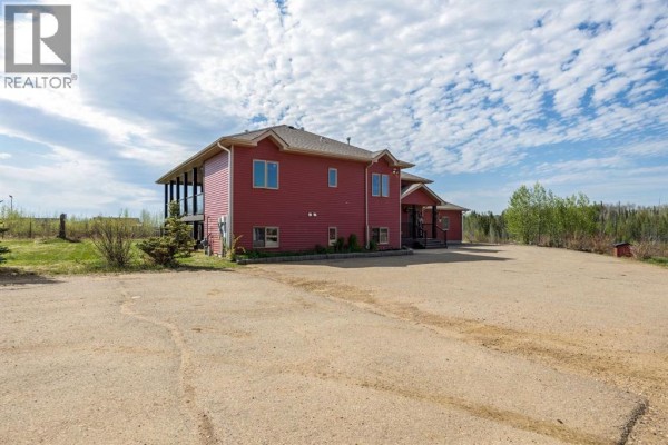 Large red detached garage or workshop with a large bay door and a smaller side entrance. - 200 Weiss Drive, Saprae Creek