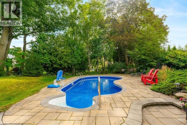 Driveway and garage of a brick house with stone accents and entryway. - 200 Woodview Crescent, Ancaster