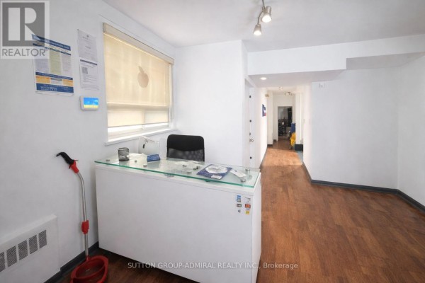 Reception area with desk, modern lighting, and laminate flooring. - 2000 Eglinton Avenue W, Toronto