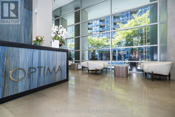 Apartment building lobby with a reception desk, seating area, and large windows. - 2003 - 81 Navy Wharf Court, Toronto
