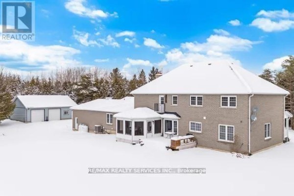 Brick house with sunroom, detached garage, and snow-covered yard - 20040 Kennedy Road, Caledon