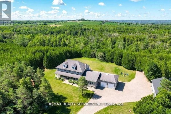 Aerial view of a house with attached garage, dormer windows, and treed lot - 20040 Kennedy Road Caledon
