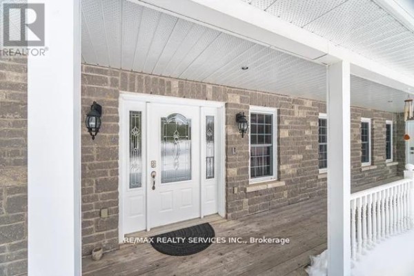 Brick exterior with white front door, decorative glass, covered porch - 20040 Kennedy Road, Caledon