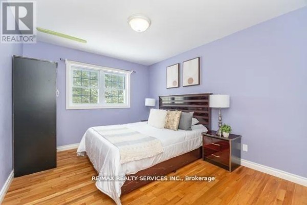 Bedroom with hardwood floors, large window, and dark headboard - 20040 Kennedy Road Caledon