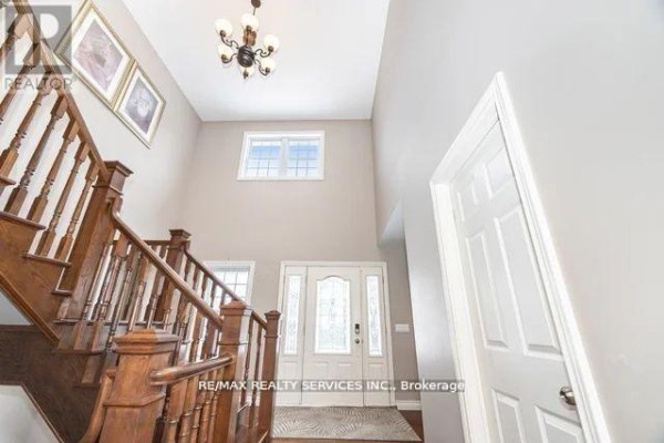 Entryway with wooden staircase, chandelier, and front door - 20040 Kennedy Road Caledon