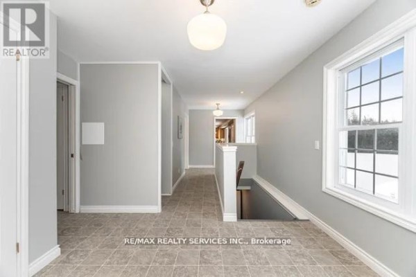 Renovated hallway with tiled floor, windows, and staircase - 20040 Kennedy Road, Caledon
