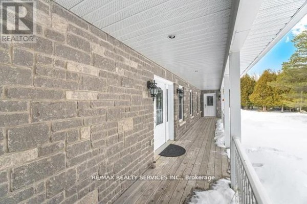 Covered front porch with brick exterior, wooden deck, light fixtures - 20040 Kennedy Road Caledon