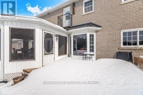 Brick back exterior with sunroom, bay window, balcony, and snow - 20040 Kennedy Road, Caledon
