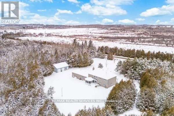 Aerial view of snow-covered house, detached outbuilding, and trees - 20040 Kennedy Road Caledon