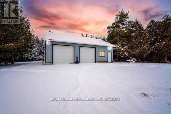 Detached garage with two white garage doors, window, and entry door - 20040 Kennedy Road, Caledon
